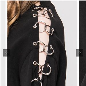 Black “pierced” sweater with cut out arm/metal details